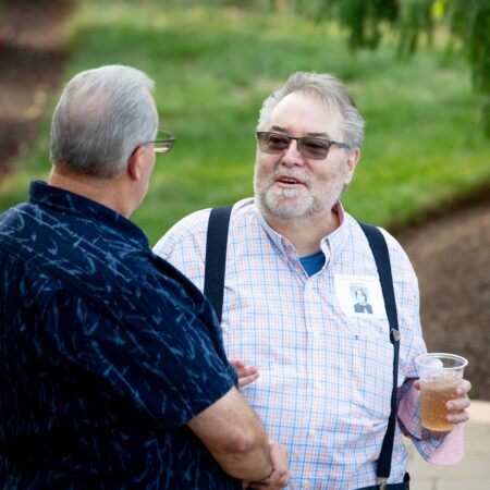 two men talking and drinking