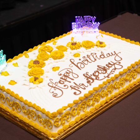 a cake with yellow frosting and purple lights